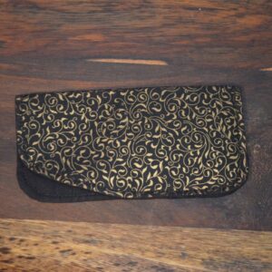 Obal na brýle je černý s elegantním zlatým vzorem vinoucích se rév a listů. Tento design je dekorativní a přidává obalu na brýle vizuální přitažlivost. Tento stylový a praktický doplněk je ideální pro ochranu vašich brýlí a přidání elegantního akcentu do vaší kabelky nebo tašky. 1